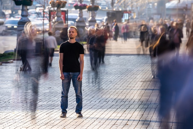 L'homme se tient dans la rue bondée