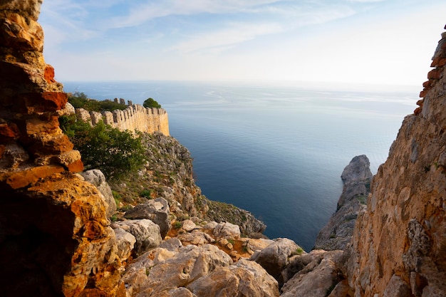 Un homme se tient sur une falaise surplombant la mer.