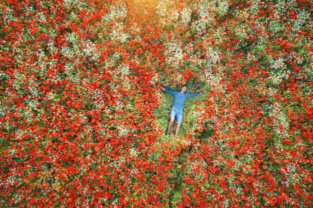 L'homme se trouve dans un champ de coquelicots