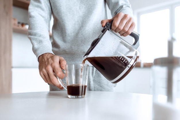 L'homme se verse une tasse de café