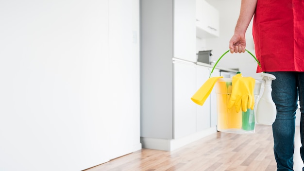 Homme avec seau de produits de nettoyage