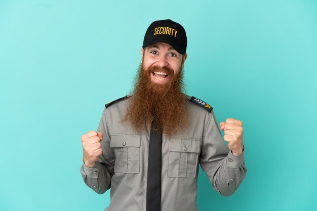 Homme de sécurité rousse isolé sur fond blanc célébrant une victoire en position de vainqueur