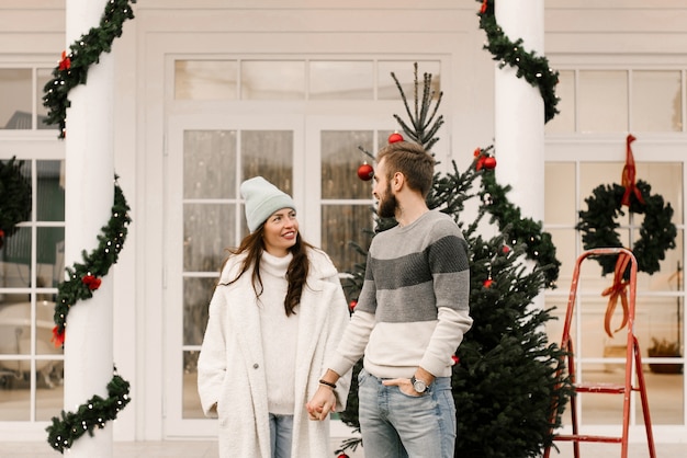 Homme séduisant et aimant et fille avec une voiture rétro rouge, concept d'histoire d'amour de Noël