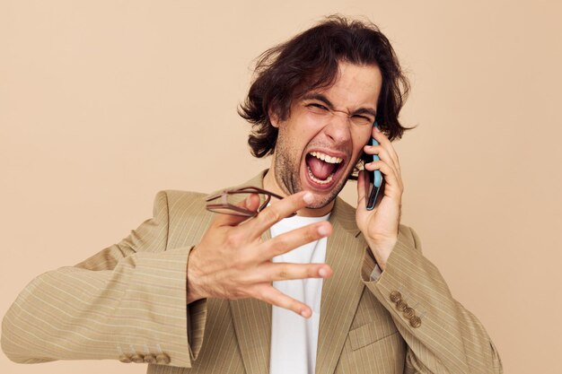 Homme séduisant en costume posant des émotions parlant au téléphone style de vie inchangé