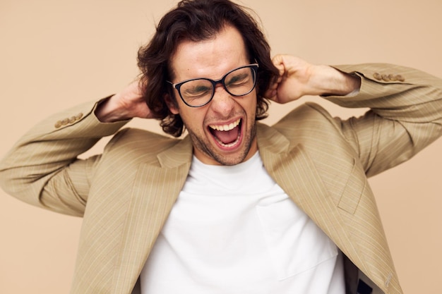 Homme séduisant en costume posant des émotions porter des lunettes fond isolé