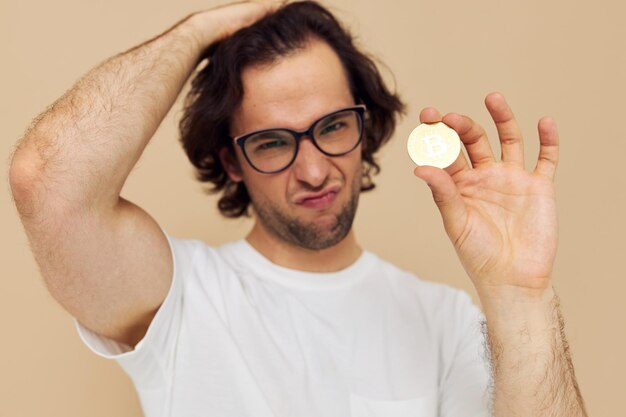 Homme séduisant dans un t-shirt blanc avec un style de vie de crypto-monnaie bitcoin inchangé