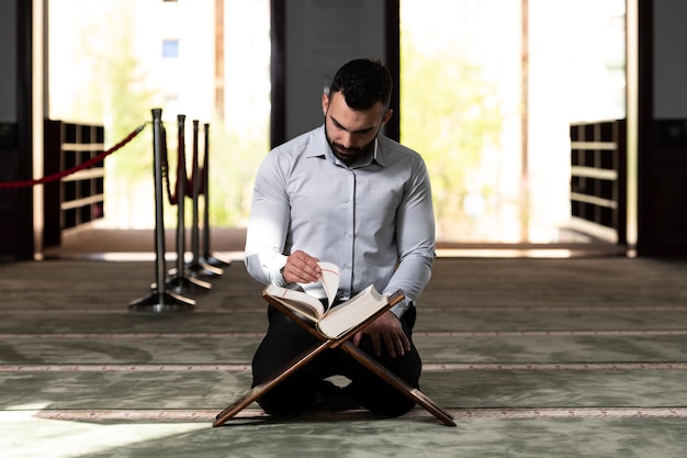 Homme séduisant faisant la prière traditionnelle à Dieu Allah dans la mosquée