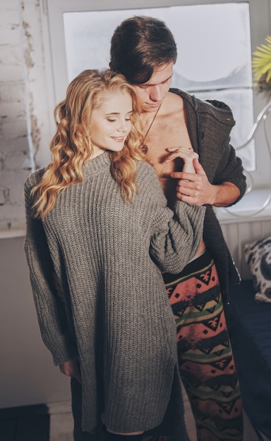 Homme séduisant et femme dans la chambre ensemble câlins mignon