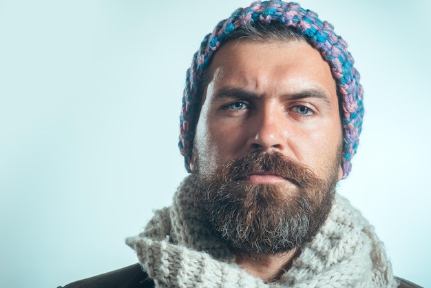 Homme séduisant de mode automne-hiver avec barbe et moustache portant un chapeau et une écharpe élégant sérieux