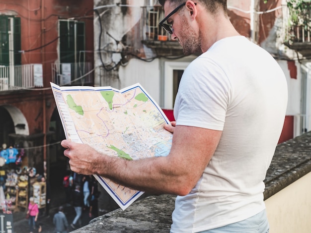 Homme séduisant en regardant une carte avec des vues