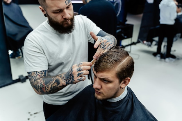 Un homme séduisant se fait couper les cheveux dans un salon de coiffure