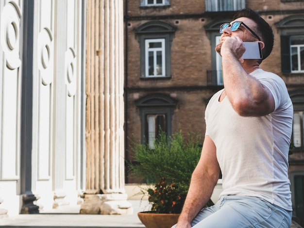 Photo homme séduisant avec un téléphone sur le fond de vives