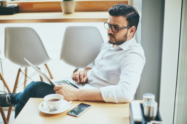 Homme séduisant travaillant au café