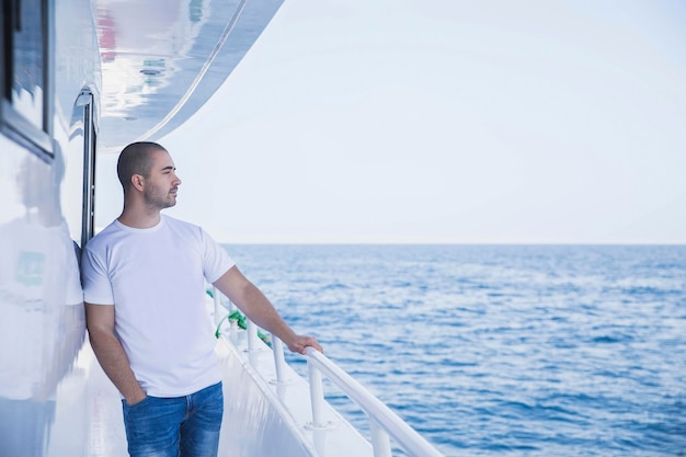 homme séduisant sur un yacht regarde au loin à la mer