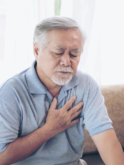 Homme senior asiatique souffrant de fortes douleurs dans sa poitrine crise cardiaque à la maison maladie cardiaque senior