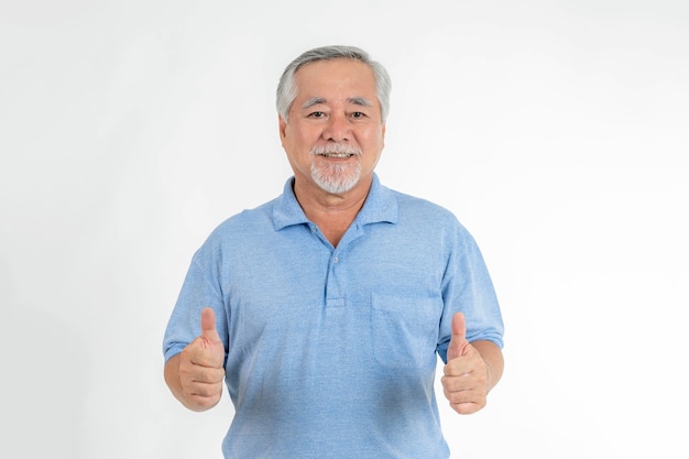 Homme senior asiatique, vieil homme donnant un pouce vers le haut se sentir heureux et en bonne santé sur fond blanc - succès senior de style de vie dans les affaires ou dans le concept de vie personnelle