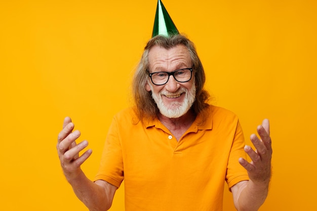 Homme senior aux cheveux gris dans un t-shirt jaune avec une casquette sur la tête amusante vue recadrée