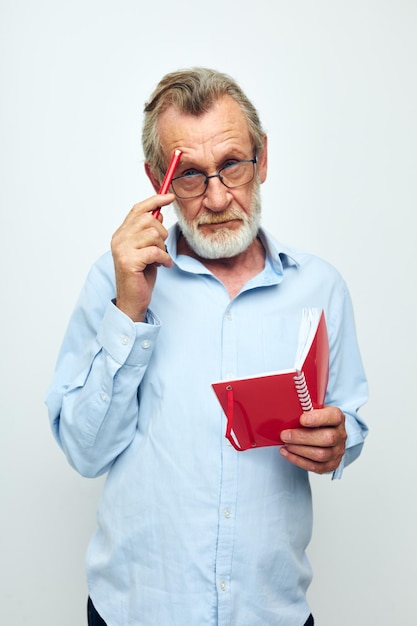 L'homme senior aux cheveux gris écrit des émotions dans un fond clair de cahier