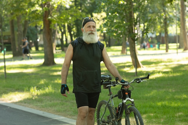 Homme senior barbu avec un vélo