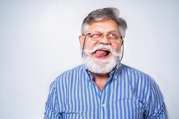 Homme senior excentrique avec portrait d'expression drôle sur la surface