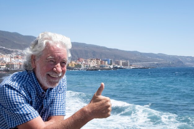 Homme senior séduisant barbu s'amusant dans une excursion en mer mer bleue et vagues blanches