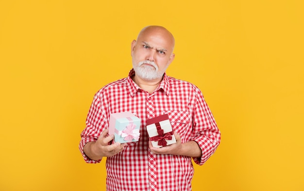 Homme senior sérieux avec boîte cadeau pour la retraite