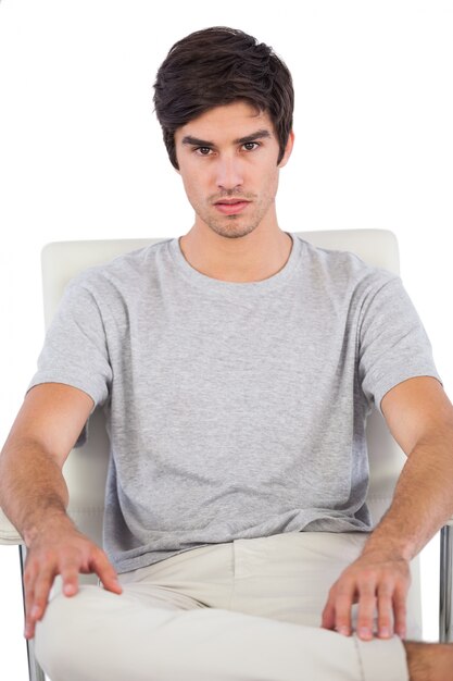 Homme sérieux assis sur une chaise de bureau