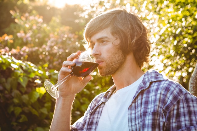 Homme sérieux, buvant du vin rouge dans le jardin