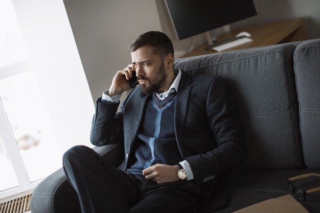 Homme sérieux en parlant sur smartphone