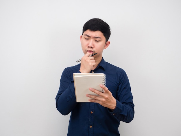 Homme sérieux regardant un cahier papier à la main en pensant au travail