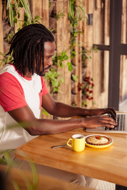 Homme sérieux travaillant sur ordinateur portable