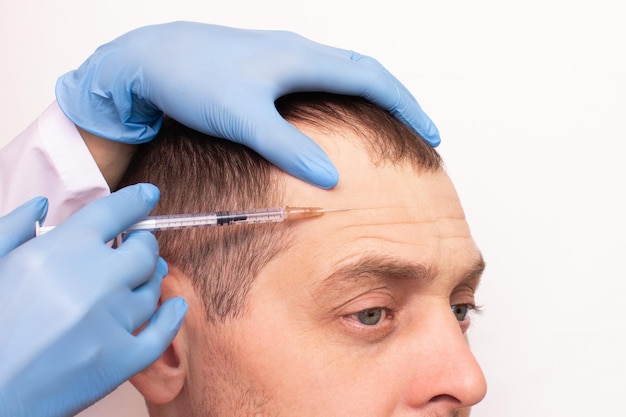 Photo un homme avec une seringue sur la tête reçoit une injection