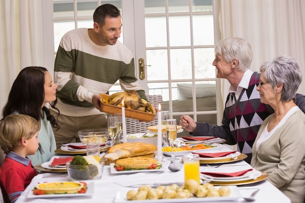 Homme servant et montrant la dinde rôtie à Noël