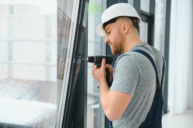 Homme de service installant la fenêtre avec un tournevis