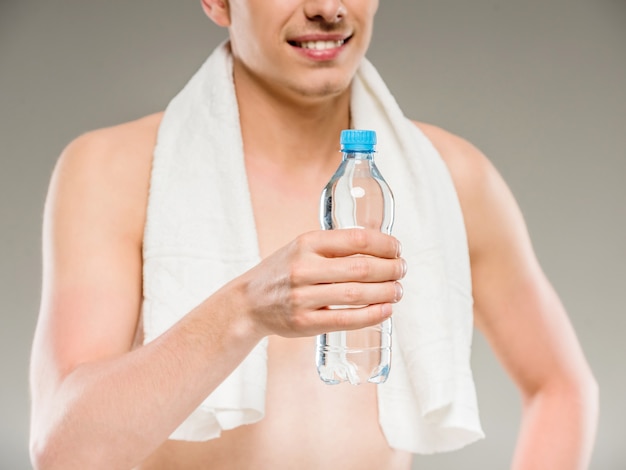 Homme avec une serviette sur les épaules, buvant de l'eau.