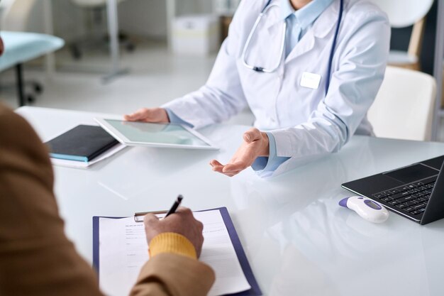 Un homme signe une carte de patient à la clinique.