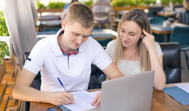 Photo un homme signe des documents assis dans un café avec une femme