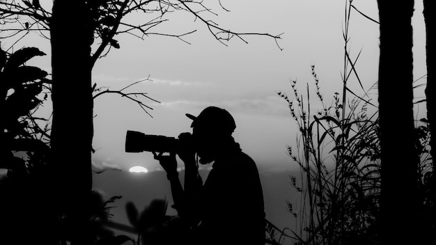 Photo un homme en silhouette photographiant contre le ciel