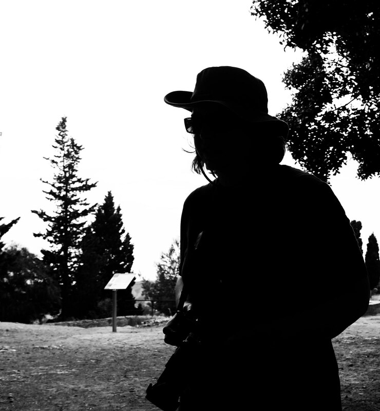 Photo un homme en silhouette portant un chapeau debout sur le terrain contre un ciel clair