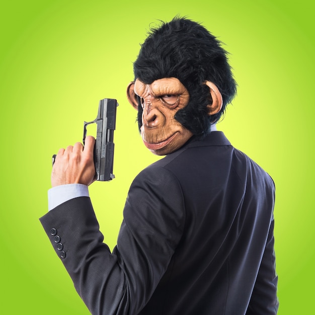 Homme singe avec un fusil sur fond coloré