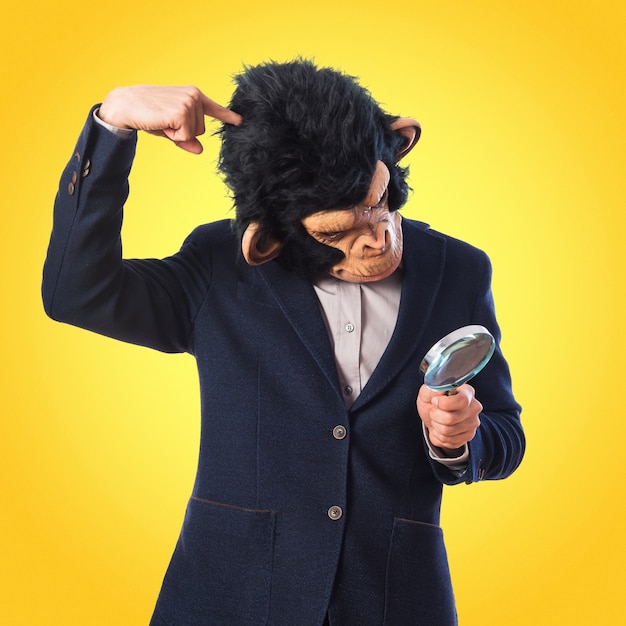 Homme singe avec une loupe sur fond coloré