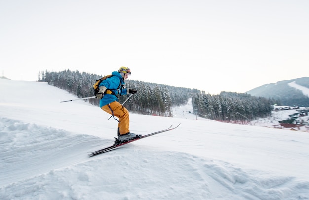 Homme de skieur au saut de la pente des montagnes