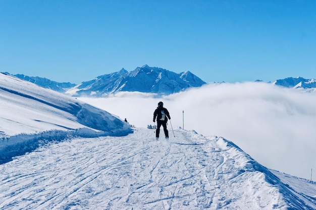 Homme skieur ski dans la station de ski de Zillertal Arena au Tyrol à Mayrhofen en Autriche dans les Alpes d'hiver. Montagnes alpines avec neige blanche et ciel bleu. Plaisir de descente sur les pistes enneigées autrichiennes.