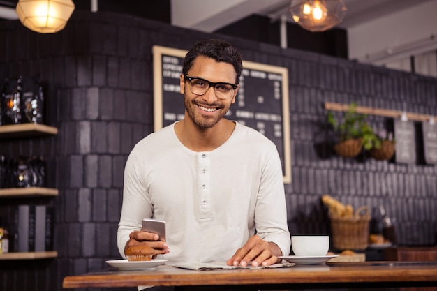 Homme avec smartphone et journal