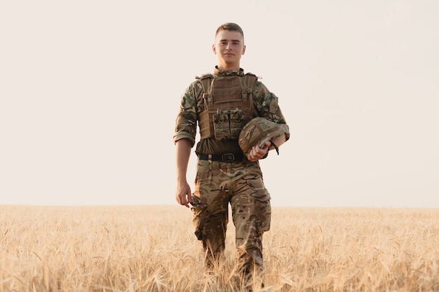 Homme soldat debout contre un champ