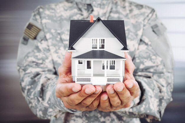 Homme soldat tenant un modèle de la maison