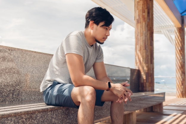 Homme solitaire assis dans une cabane au bord de la mer