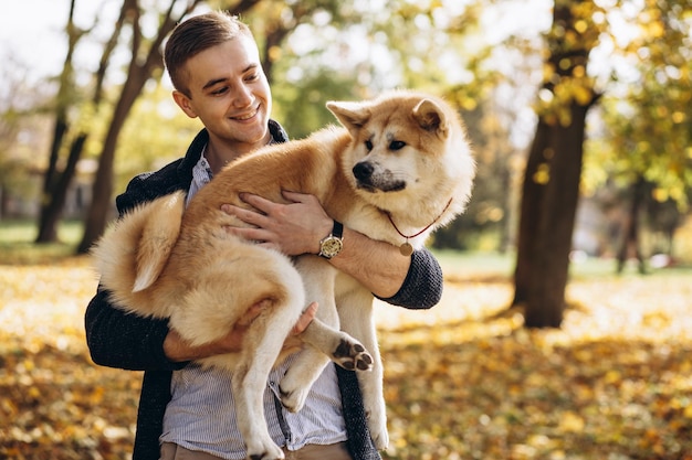 Homme avec son chien marchant dans le parc d'automne