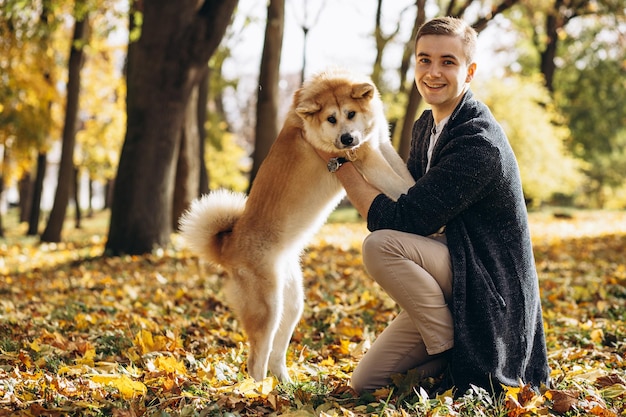 Homme avec son chien marchant dans le parc d'automne