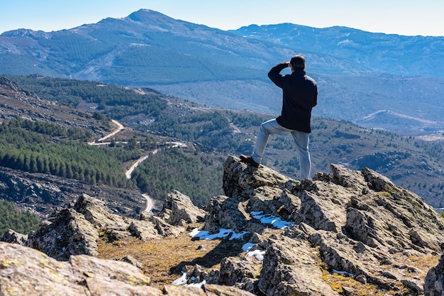 L'homme avec son dos a grimpé sur des rochers tout en contemplant le paysage de montagne dans la Sierra del Rincon Madrid